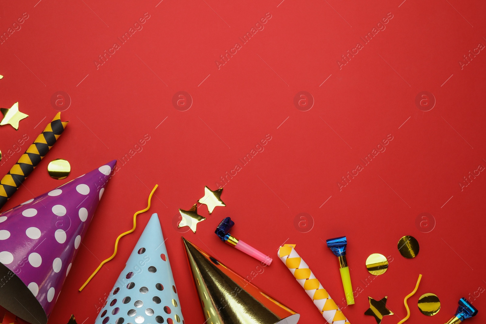 Photo of Flat lay composition with party hats and other festive items on red background. Space for text