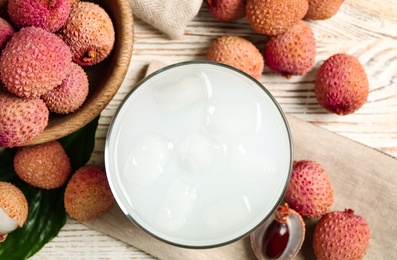 Photo of Fresh lychee juice and fruits on white wooden table, flat lay