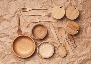 Photo of Set of modern cooking utensils on brown parchment, flat lay