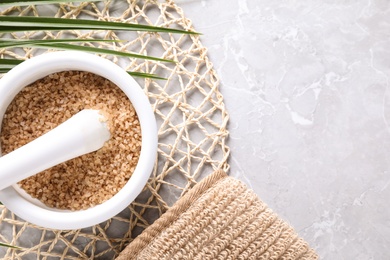 Photo of Flat lay composition with brown sea salt on marble background, space for text. Spa treatment