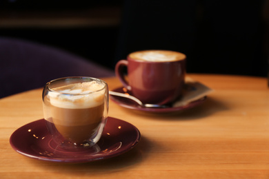 Photo of Aromatic coffee on wooden table in cafe. Space for text