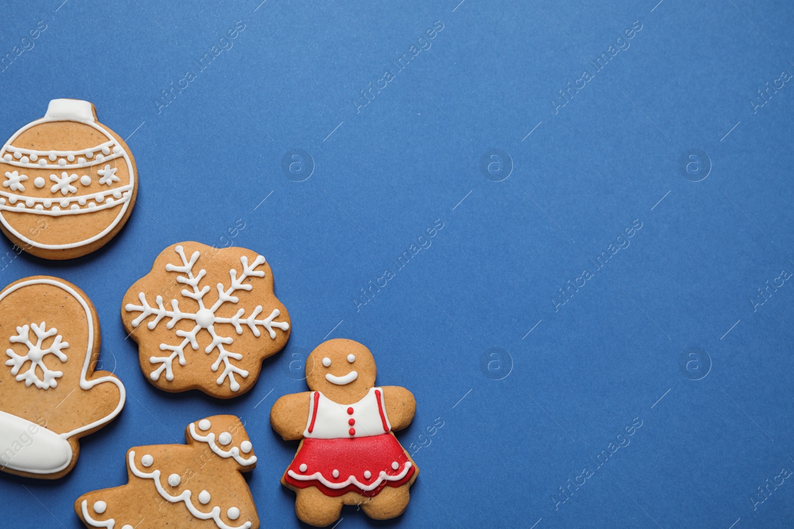 Photo of Flat lay composition with tasty homemade Christmas cookies on blue background, space for text