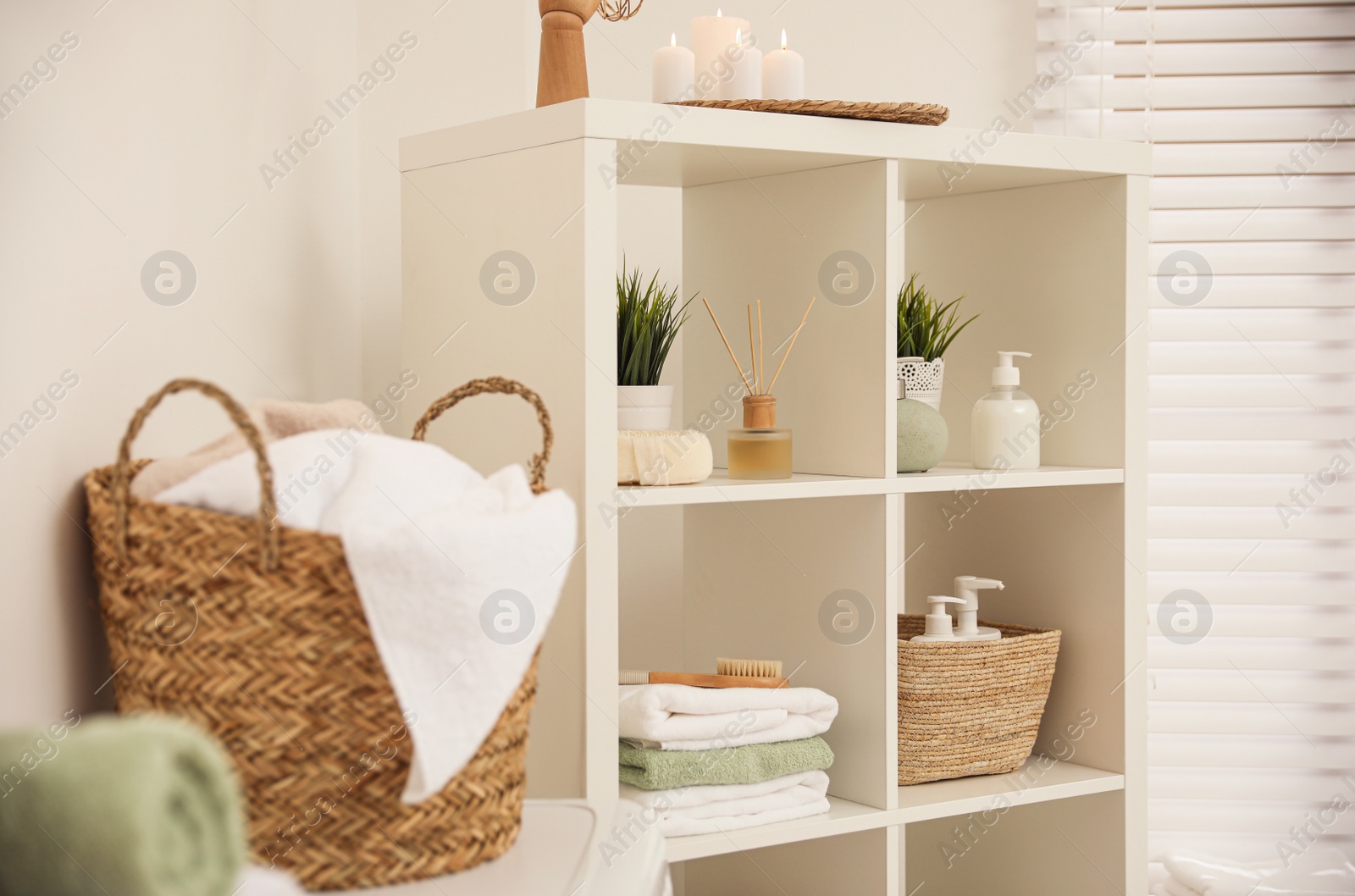 Photo of White shelves with different items in bathroom