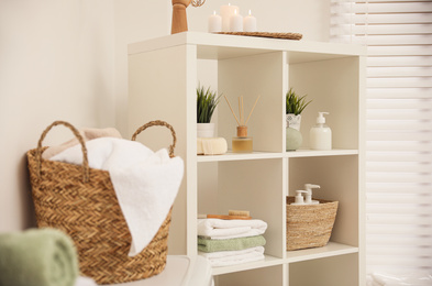 Photo of White shelves with different items in bathroom