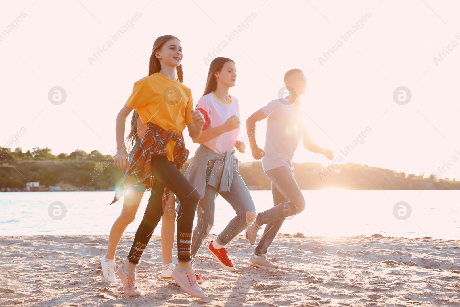 Photo of Group of children running on beach. Summer camp