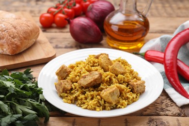 Delicious rice with chicken served on wooden table, closeup