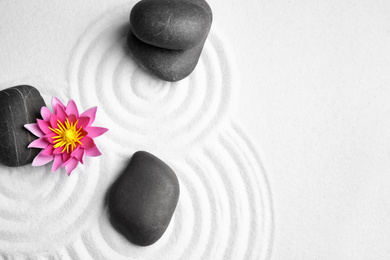 Zen garden. Beautiful lotus flower and stones on white sand, flat lay