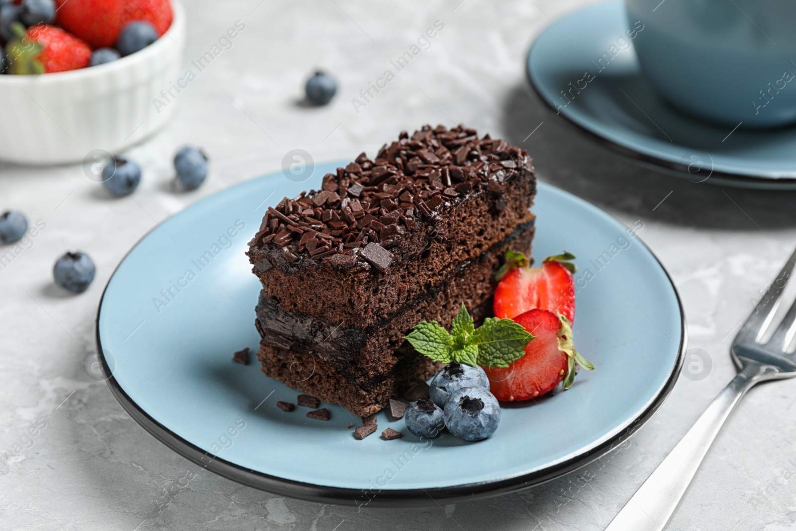 Photo of Delicious fresh chocolate cake with berries on table