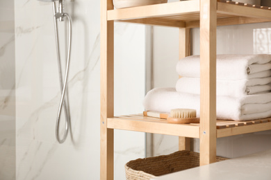 Photo of Shelving unit with clean towels in bathroom interior