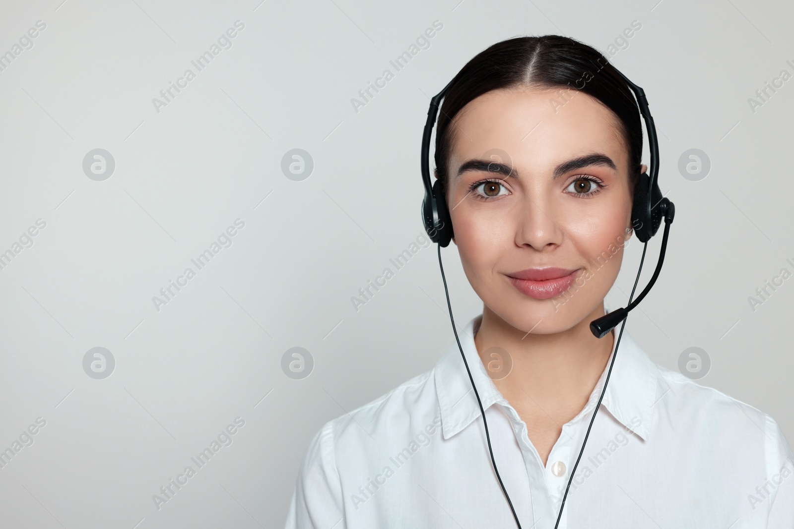 Photo of Hotline operator with modern headset on light grey background, space for text. Customer support