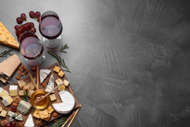 Photo of Cheese plate with honey, grapes and nuts on grey table, flat lay, Space for text