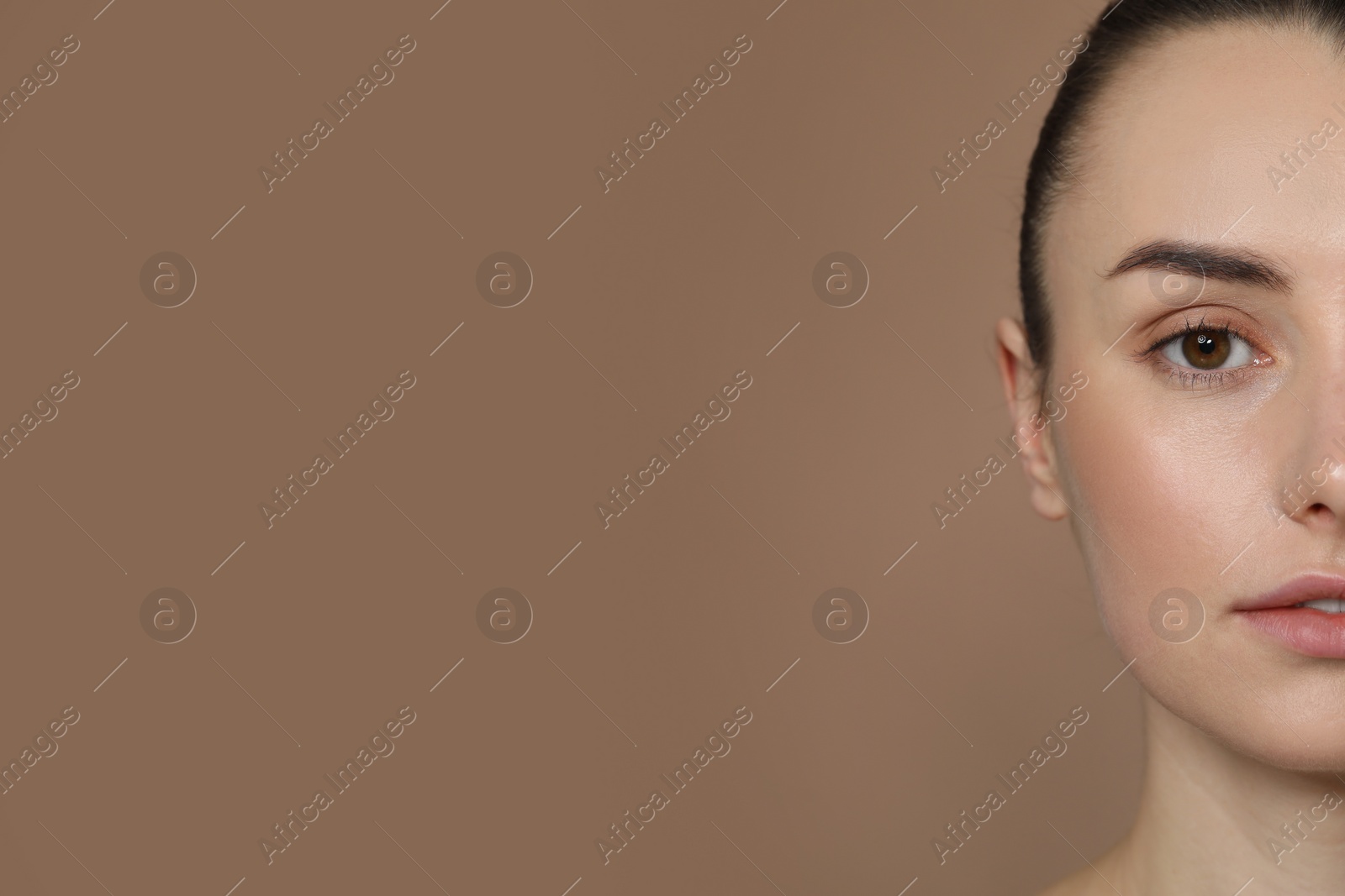 Photo of Beautiful young woman with healthy skin on light brown background, closeup. Space for text