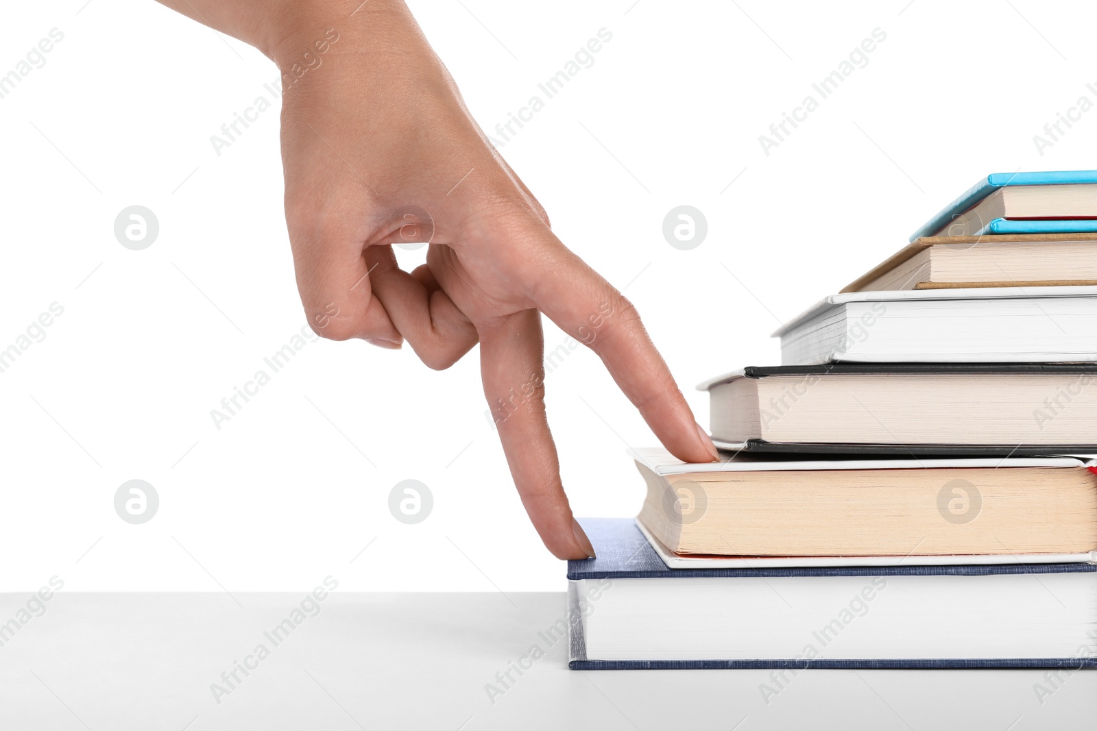 Photo of Woman imitating stepping up on books with her fingers against white background, closeup