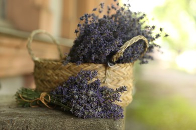 Photo of Beautiful lavender flowers and wicker basket outdoors