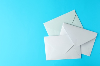 Photo of White paper envelopes on light blue background, flat lay. Space for text