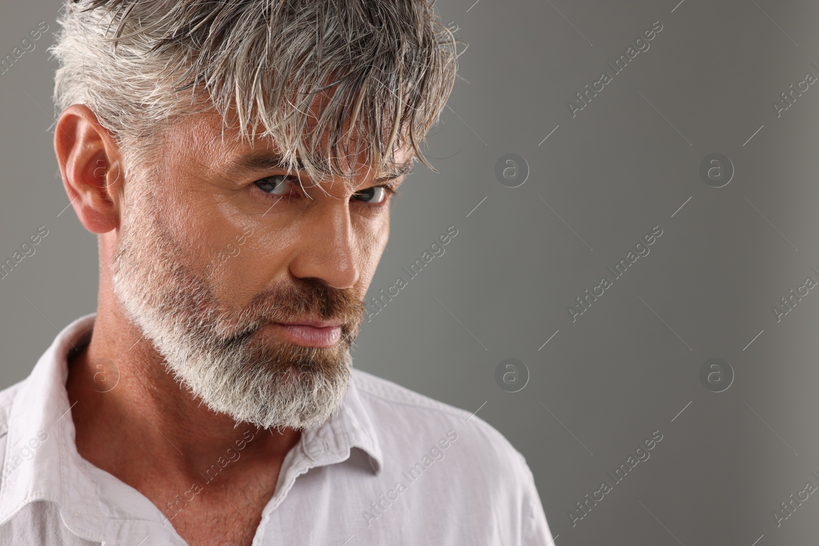 Photo of Portrait of confident man with beautiful hairstyle on light grey background. Space for text