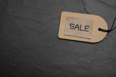 Photo of Tag with word Sale on dark stone table, top view and space for text. Black Friday