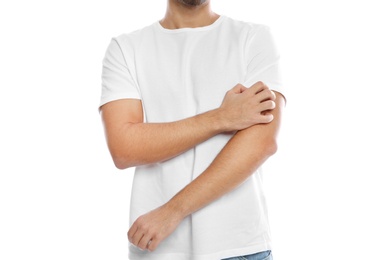 Young man scratching arm on white background, closeup. Annoying itch