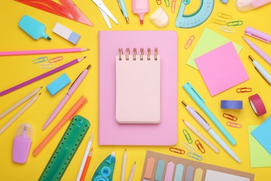 Flat lay composition with notebooks and other school stationery on yellow background, space for text. Back to school