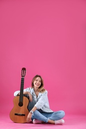 Photo of Young woman with acoustic guitar on color background