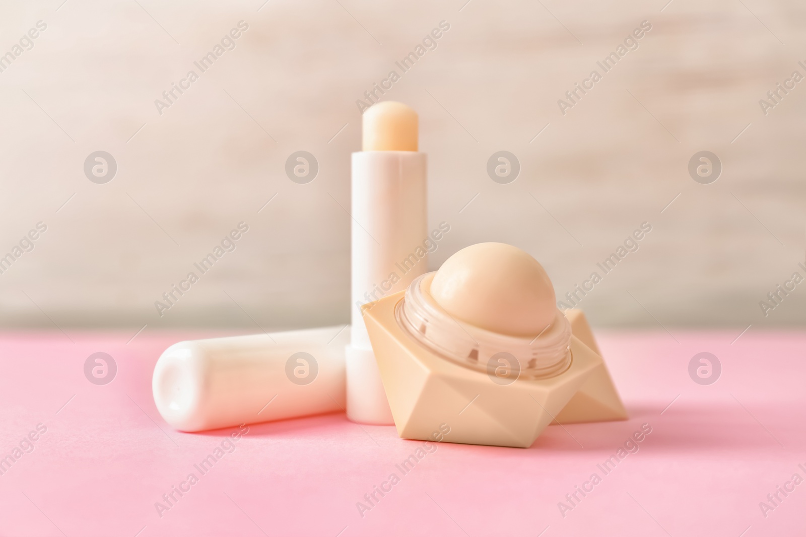 Photo of Hygienic lipstick and balm on color table