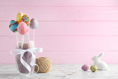 Photo of Delicious sweet cake pops on marble table, space for text. Easter holiday