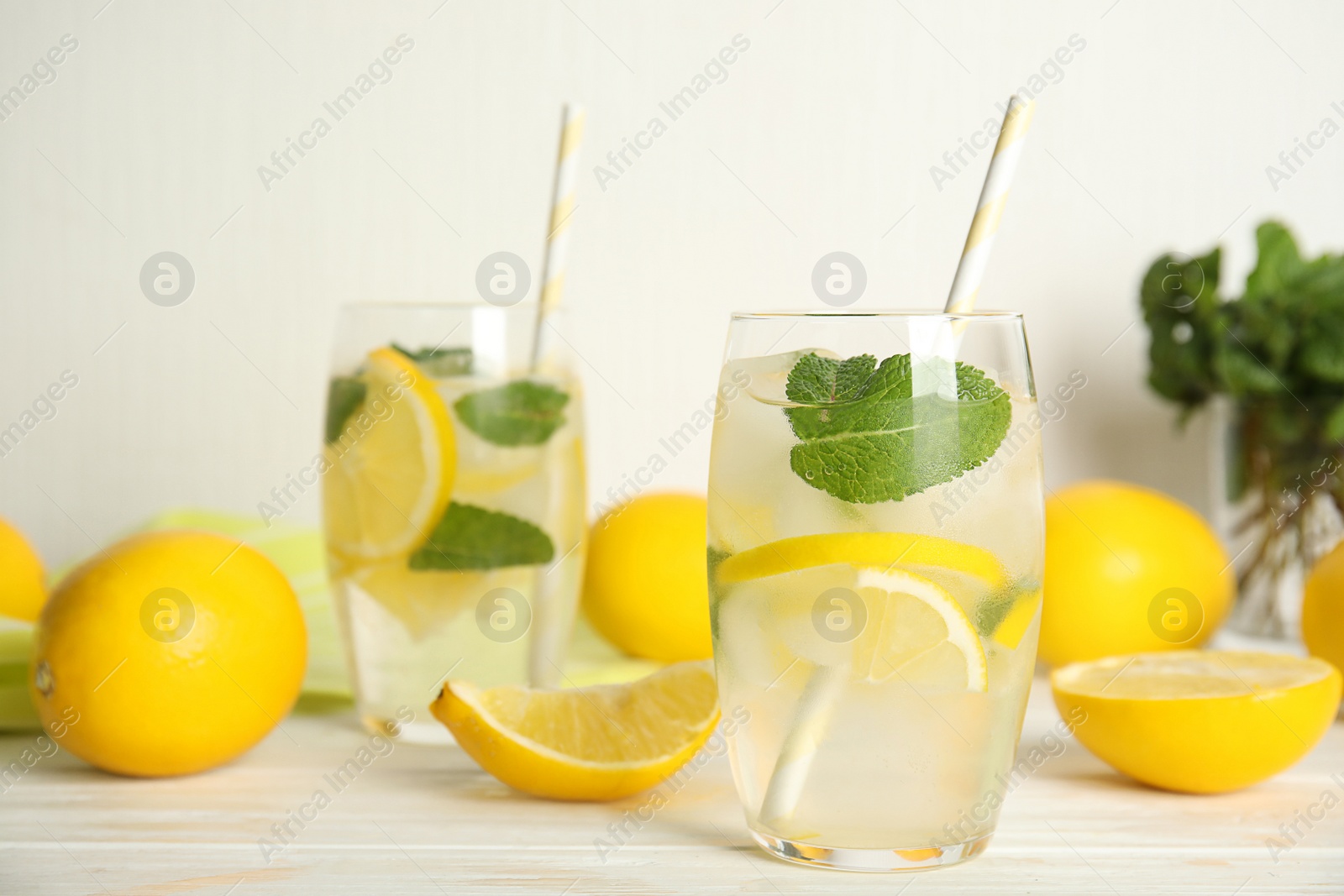 Photo of Cool freshly made lemonade and fruits on white wooden table