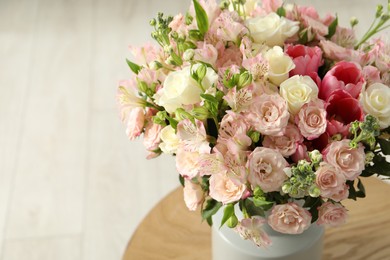 Photo of Beautiful bouquet of fresh flowers in vase on wooden table, space for text