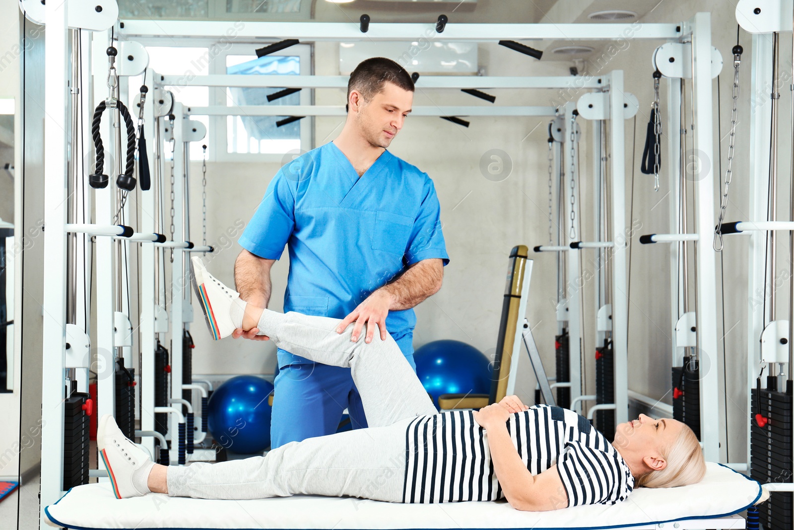 Photo of Physiotherapist working with patient in rehabilitation center