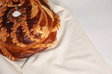 Korovai on white table, above view. Ukrainian bread and salt welcoming tradition