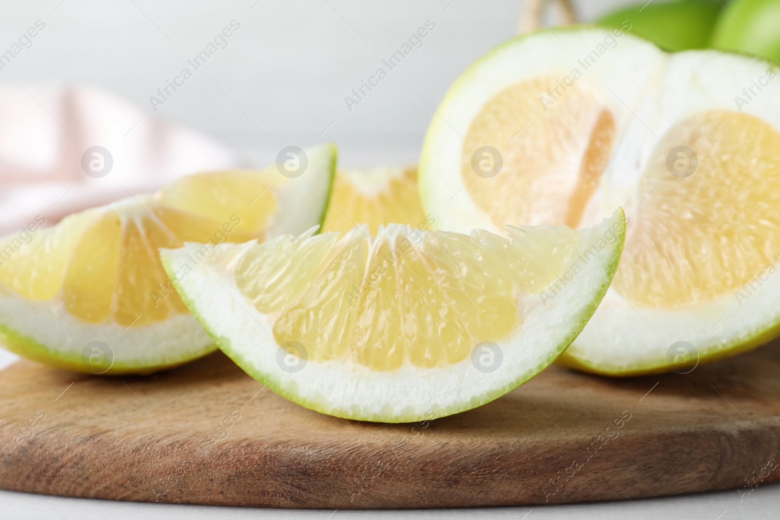 Photo of Cut fresh sweetie on wooden board, closeup