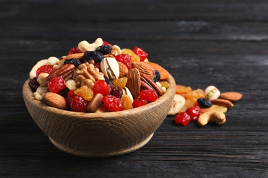 Photo of Bowl with different dried fruits and nuts on table. Space for text