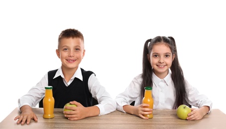 Photo of Happy children at school table with healthy food on white background
