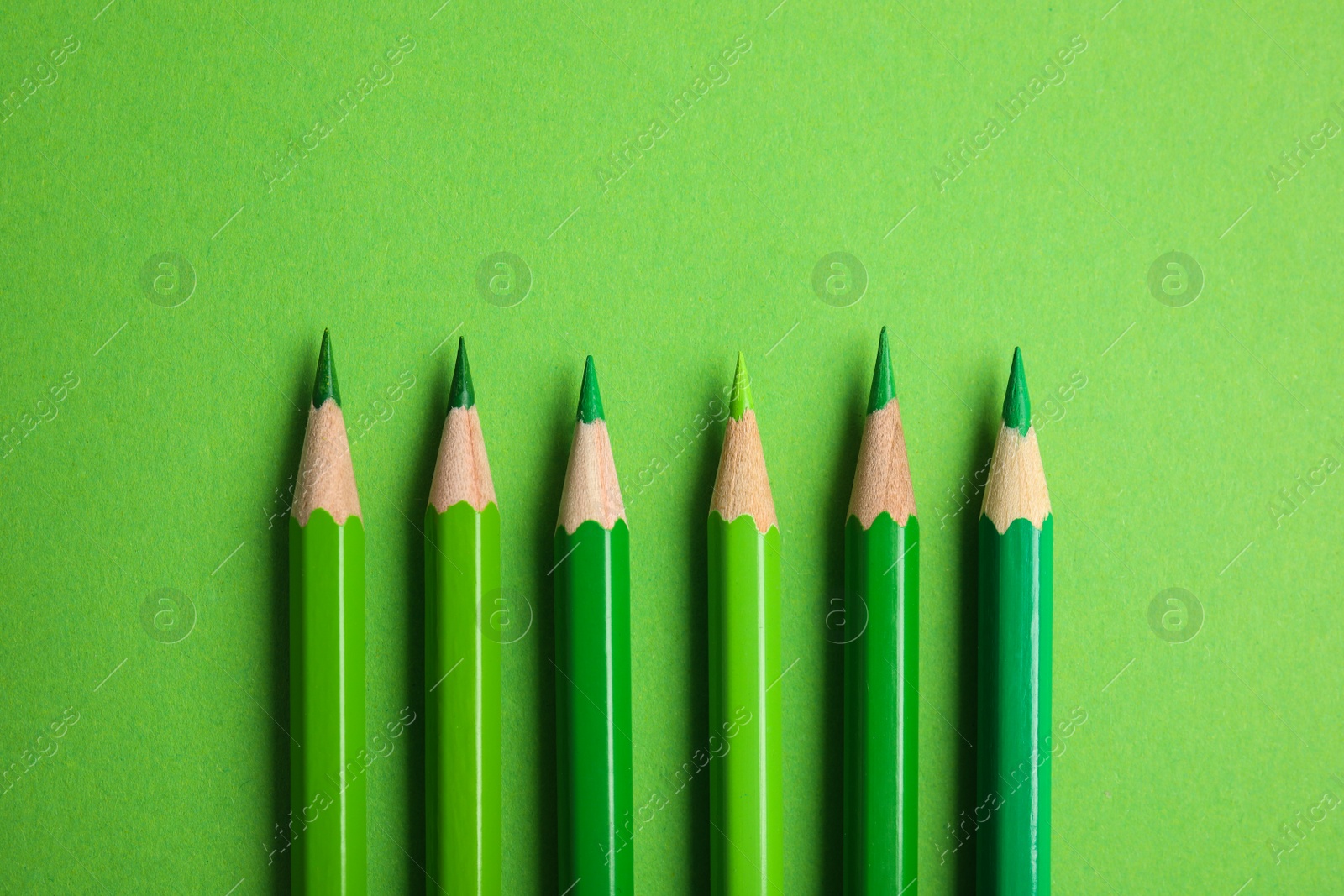 Photo of Flat lay composition with color pencils on green background