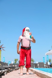 Authentic Santa Claus with cocktail near pool at resort