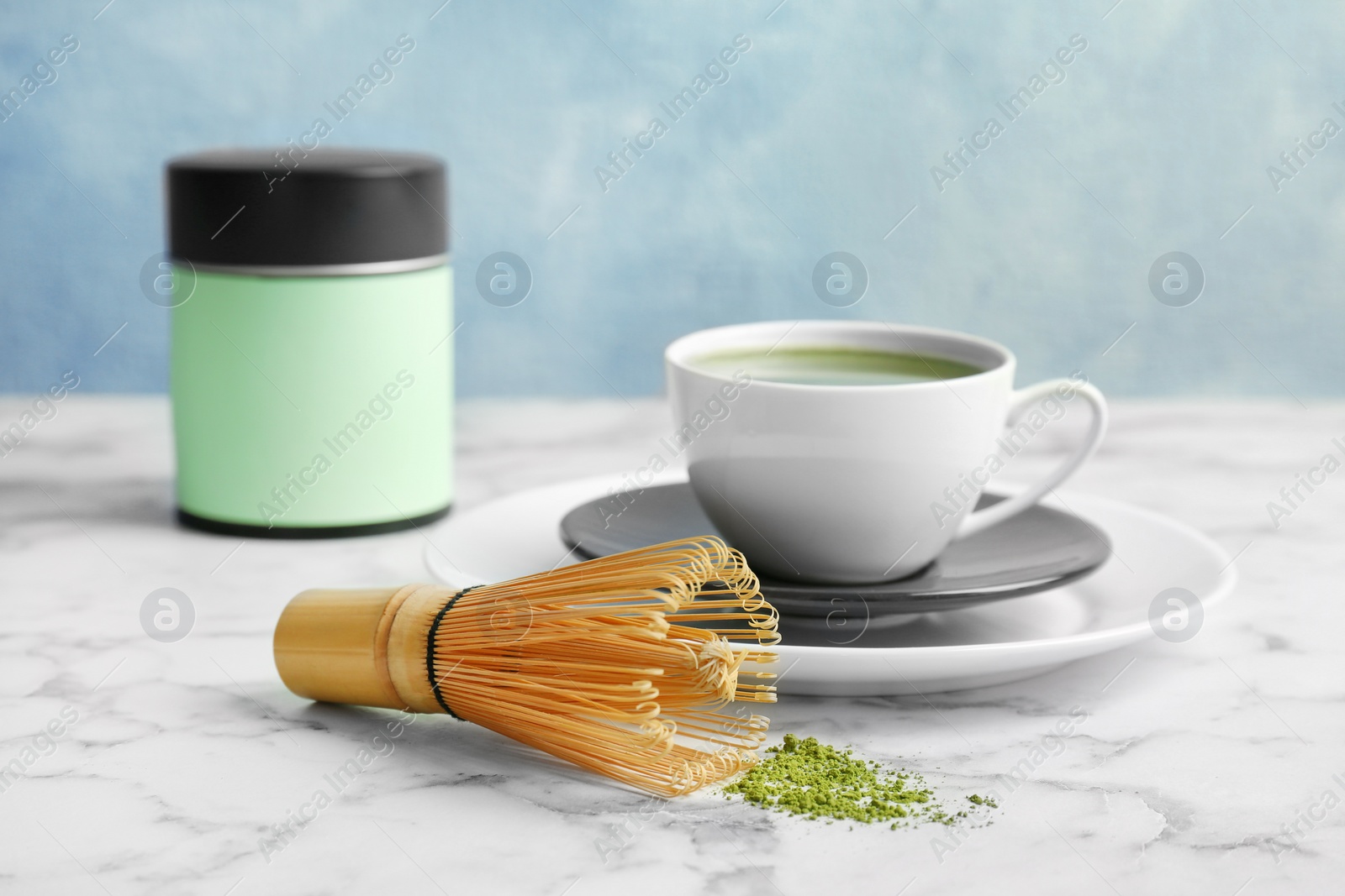 Photo of Cup of fresh matcha tea and chasen on table