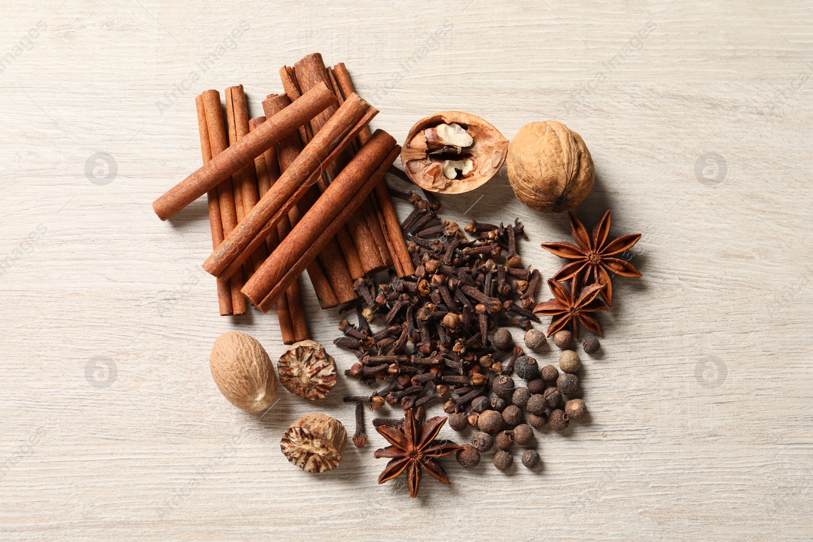 Photo of Different spices and nuts on wooden table, flat lay