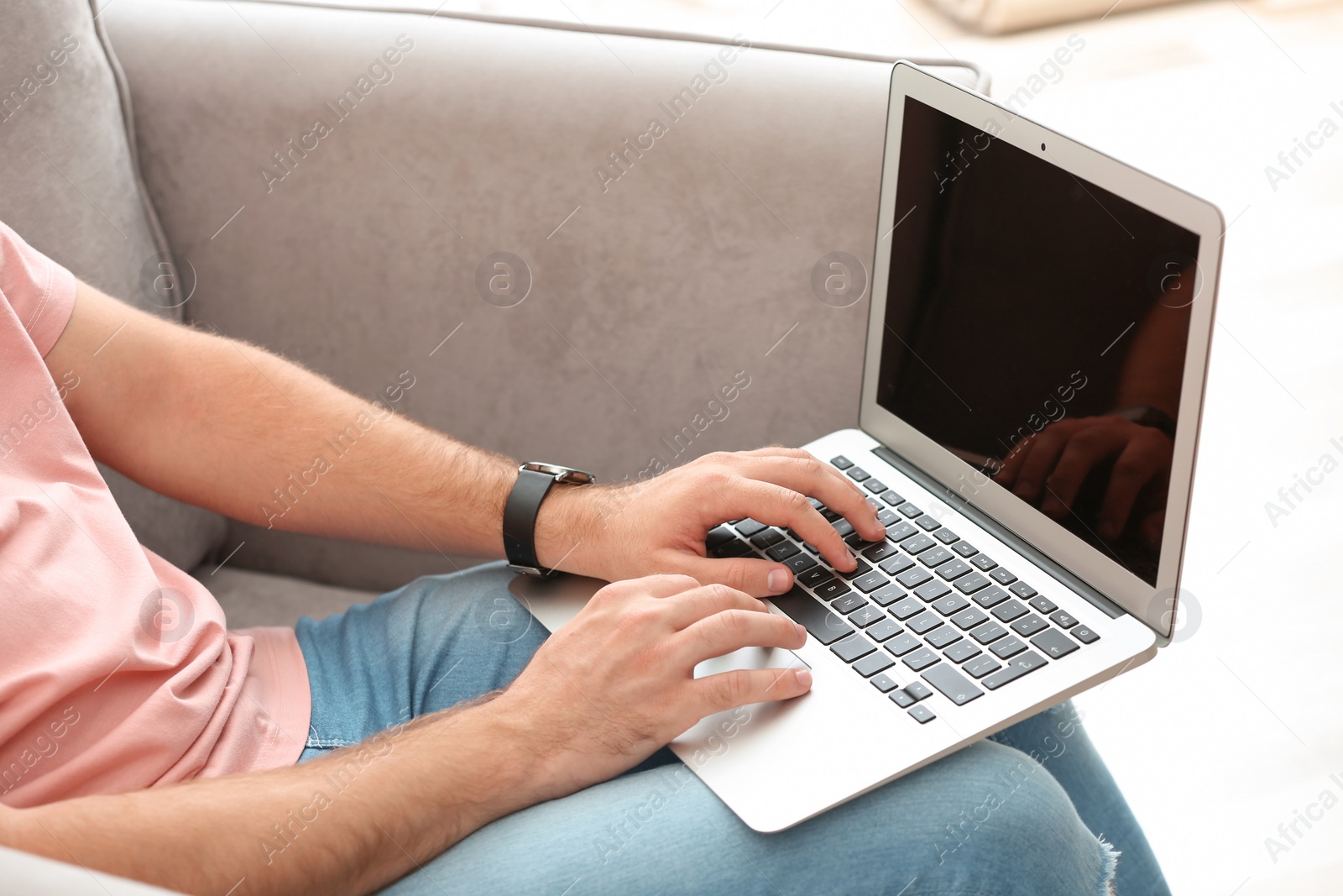 Photo of Young man working with laptop indoors, closeup