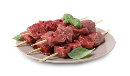 Photo of Wooden skewers with cut fresh beef meat, basil leaves and spices isolated on white