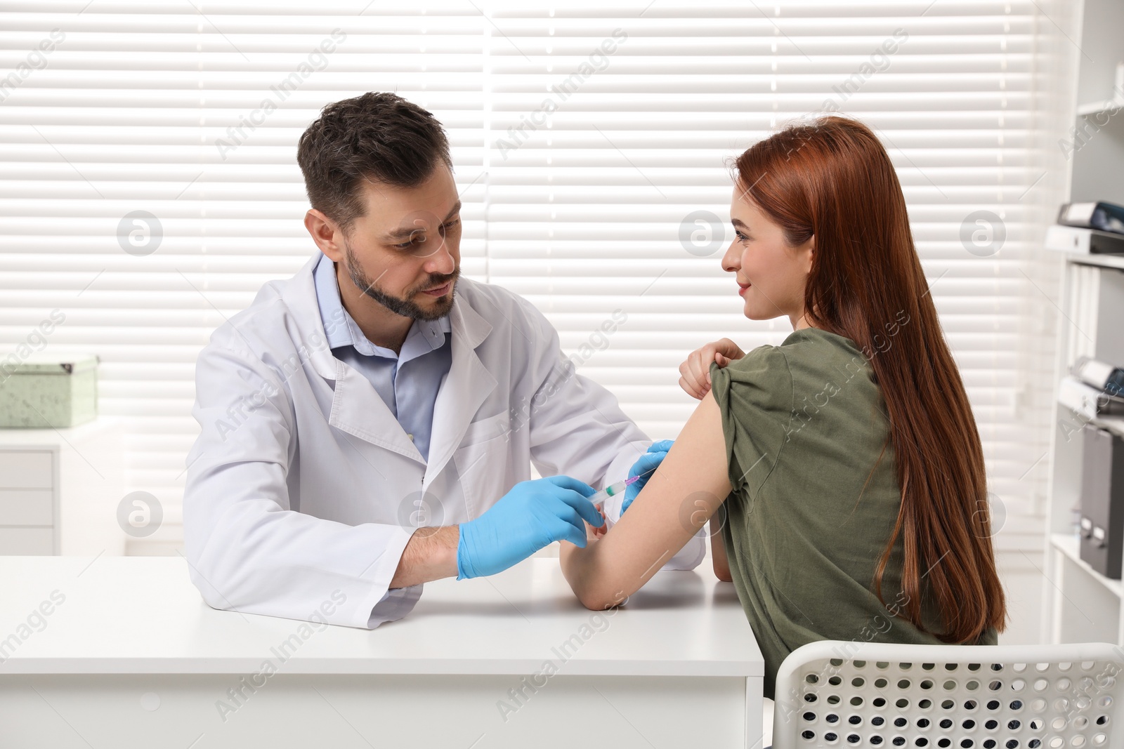 Photo of Doctor giving hepatitis vaccine to patient in clinic