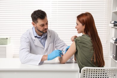 Doctor giving hepatitis vaccine to patient in clinic