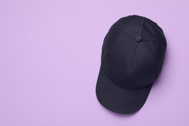 Photo of Baseball cap on violet background, top view. Space for text