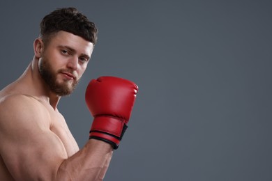 Photo of Man in boxing gloves on grey background. Space for text