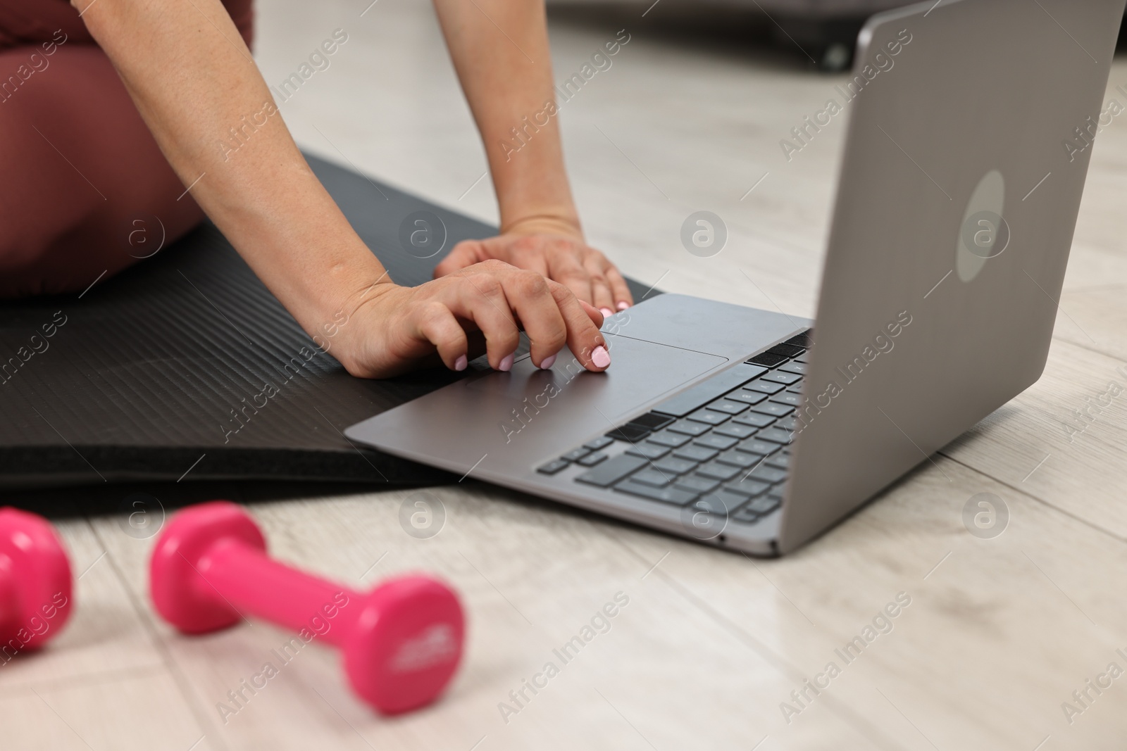 Photo of Online fitness trainer. Woman watching tutorial on laptop indoors, closeup