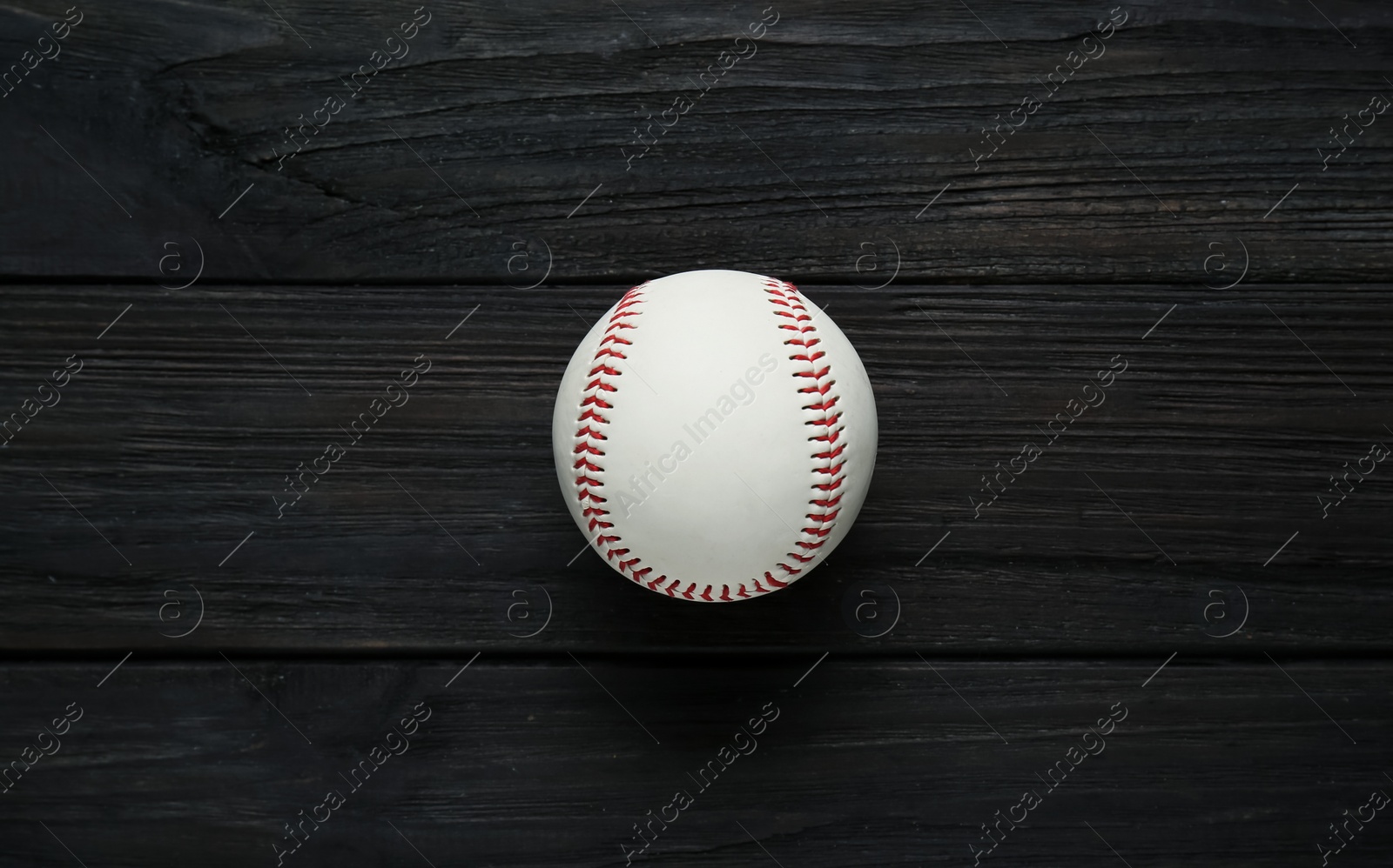 Photo of Baseball ball on black wooden table, top view. Sports game