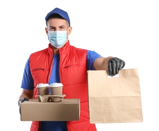 Photo of Courier in medical mask holding packages with takeaway food and drinks on white background. Delivery service during quarantine due to Covid-19 outbreak