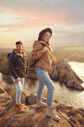 Couple of hikers with backpacks enjoying beautiful view near mountain river