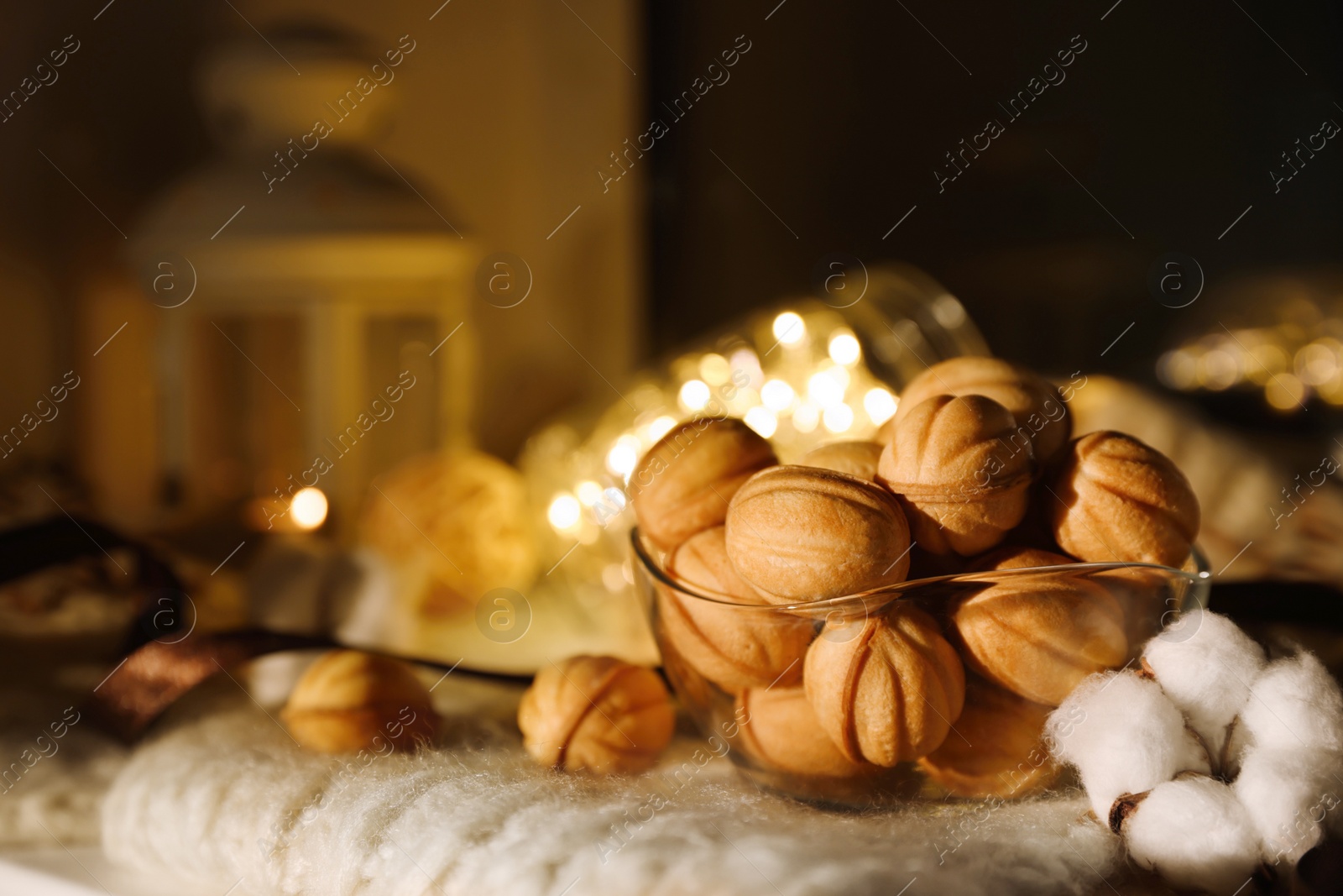 Photo of Delicious nut shaped cookies with boiled condensed milk on knitted fabric. Space for text
