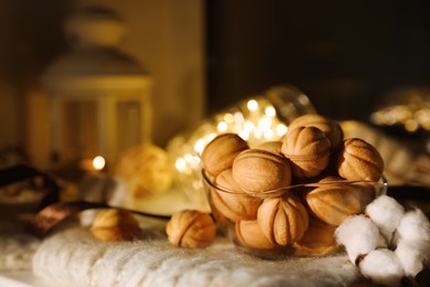 Photo of Delicious nut shaped cookies with boiled condensed milk on knitted fabric. Space for text