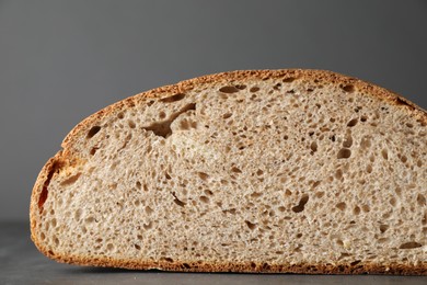 Piece of freshly baked sourdough bread on grey table, closeup